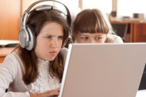 Two schoolgirls concentrated on their task with notebook