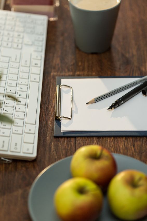 Juicy apples and coffee cup on workplace